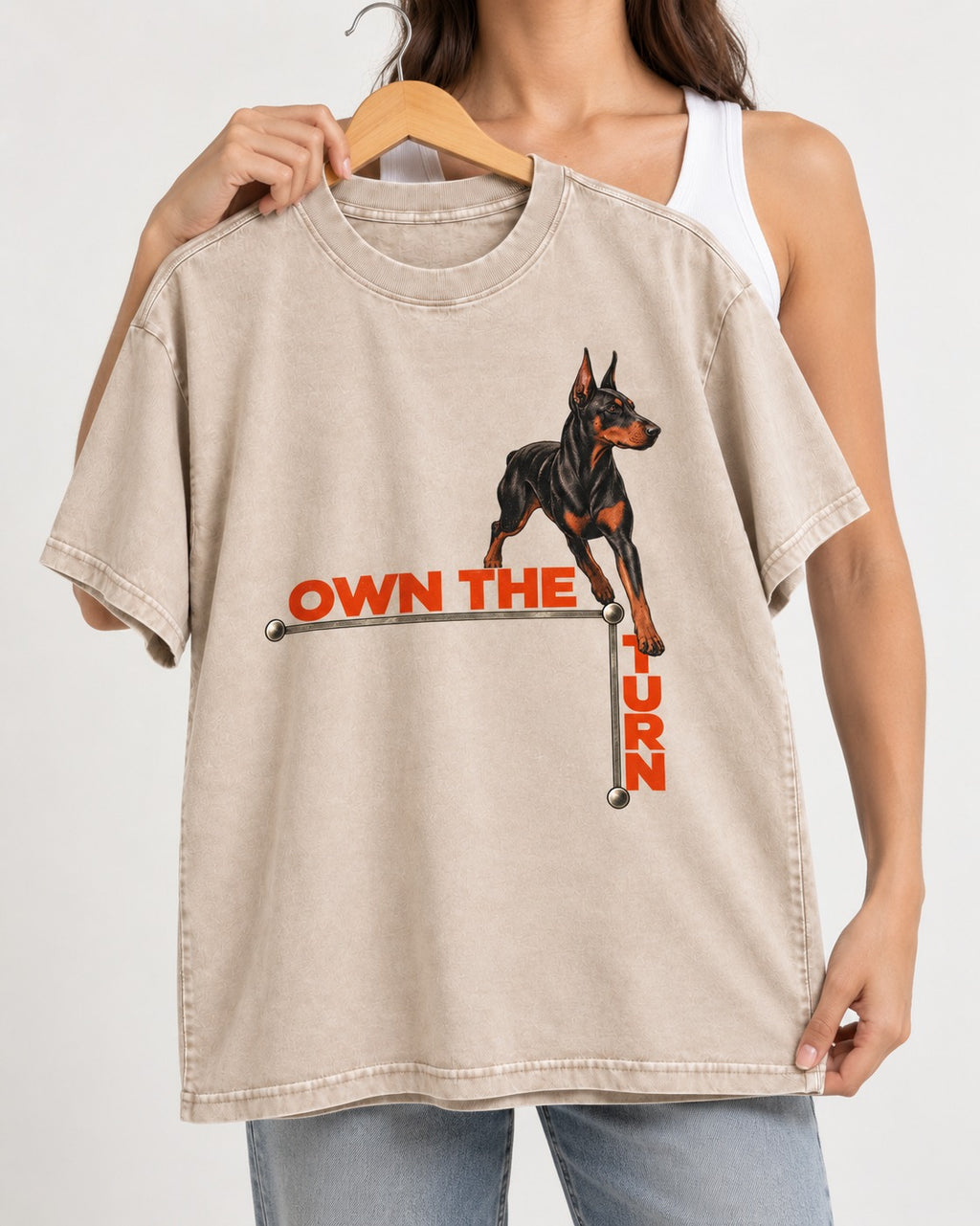 Own the Turn Doberman Washed Tee in Apricot, held up on a hanger