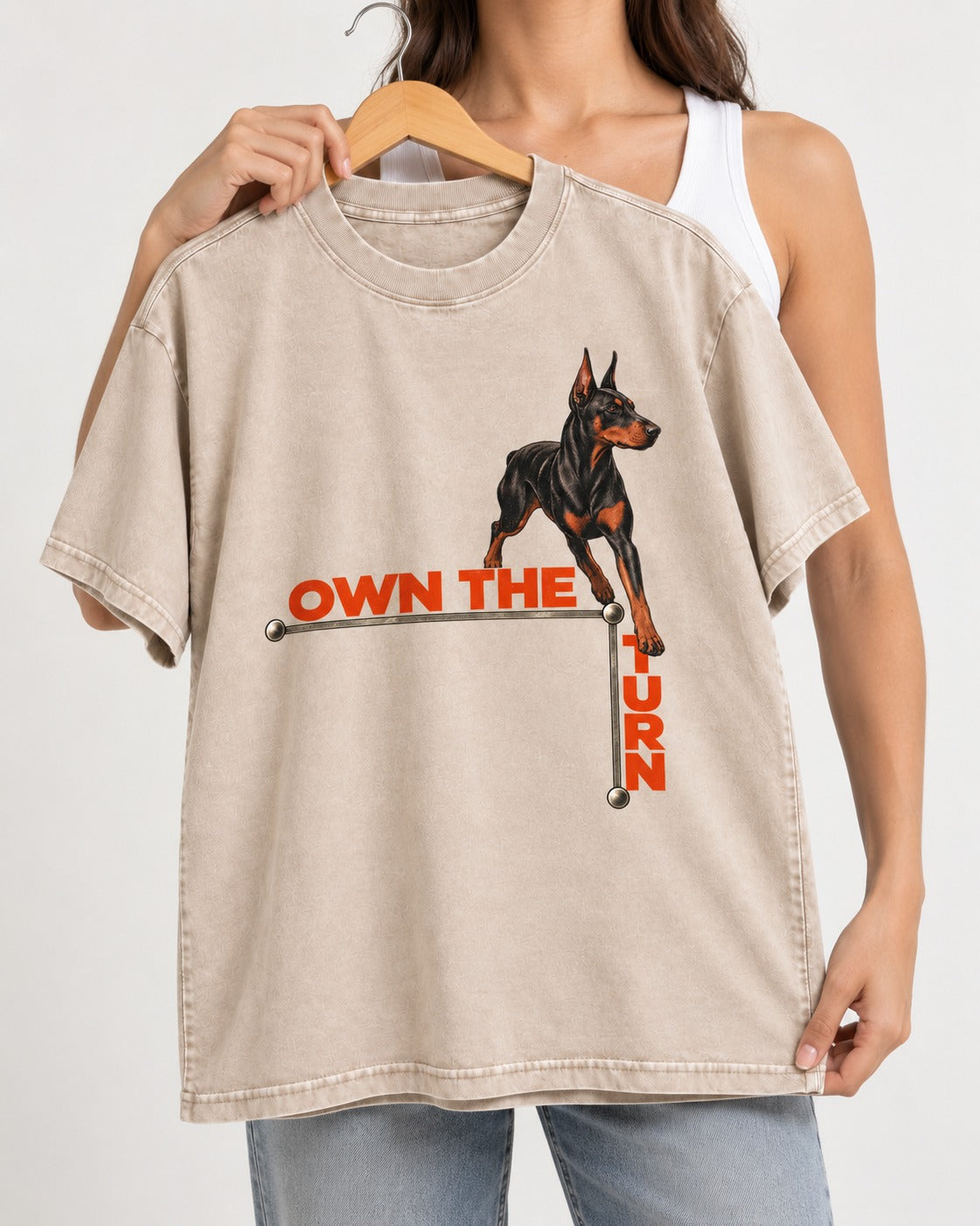 Own the Turn Doberman Washed Tee in Apricot, held up on a hanger