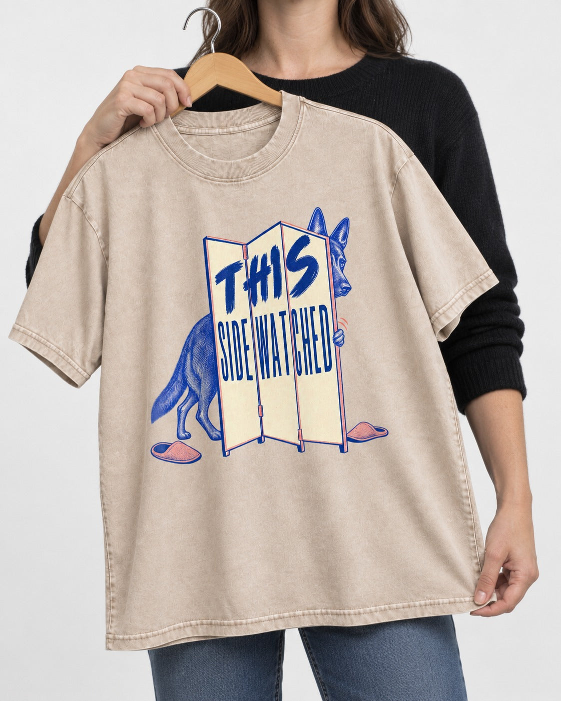 This Side Watched by German Shepherd Dog Washed Tee in Apricot, held up on a hanger