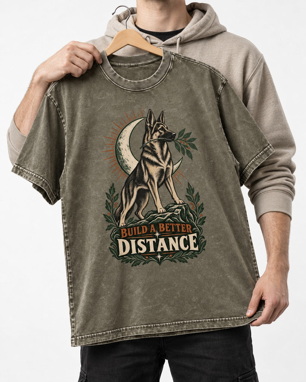 Build A Better Distance Moon Woodcut German Shepherd Dog Graphic Washed Tee in Army Green, held up on a hanger