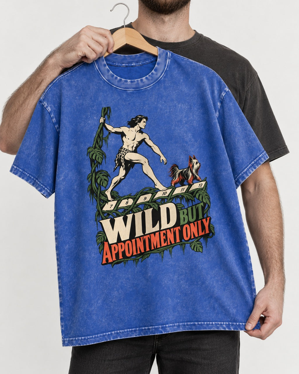 Yorkshire Terrier Wild but Appointment Only Jungle Calendar Graphic Washed Tee in Royal Blue, held up on a hanger