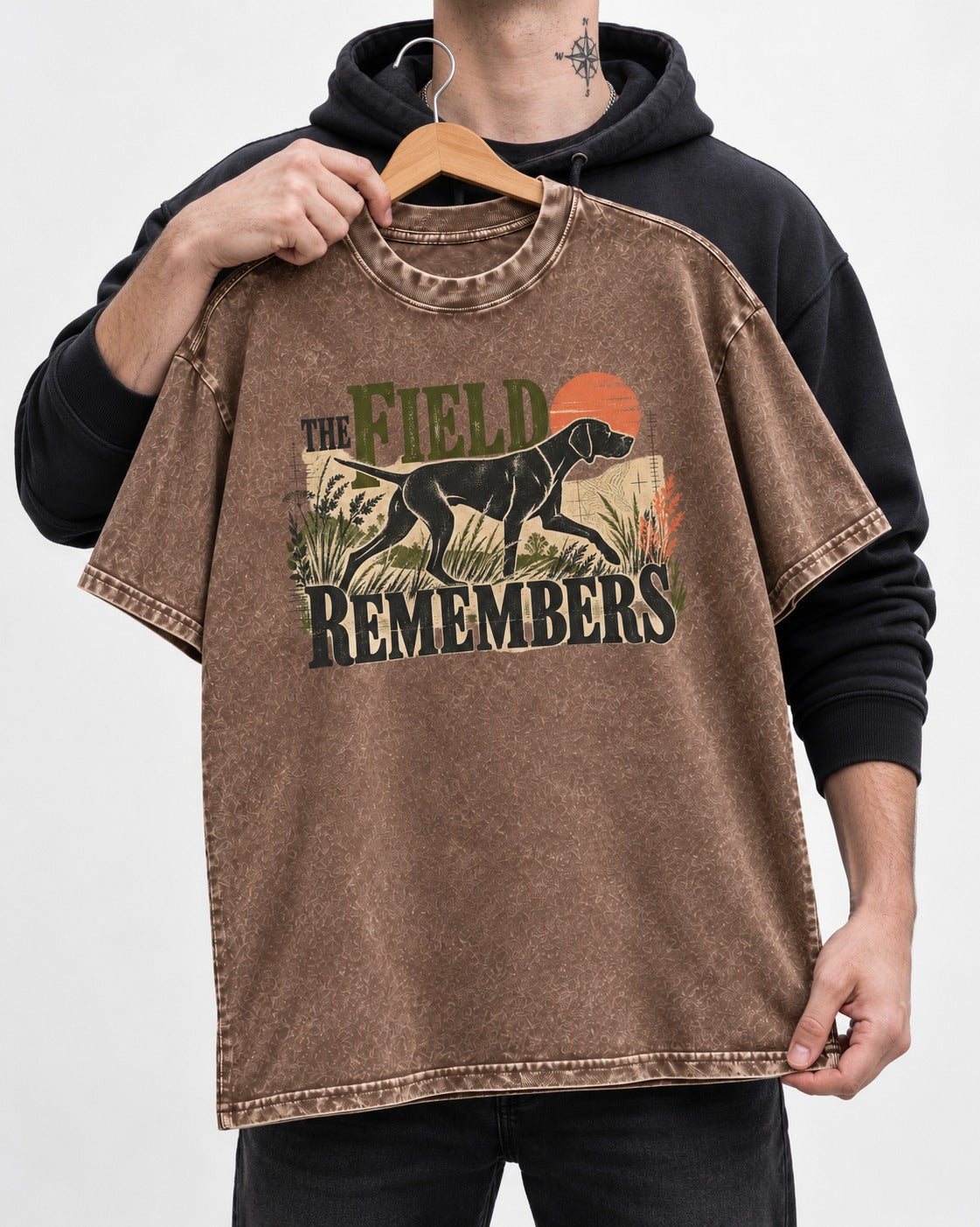 The Field Remembers German Shorthaired Pointer Washed Tee in Coffee, held up on a hanger