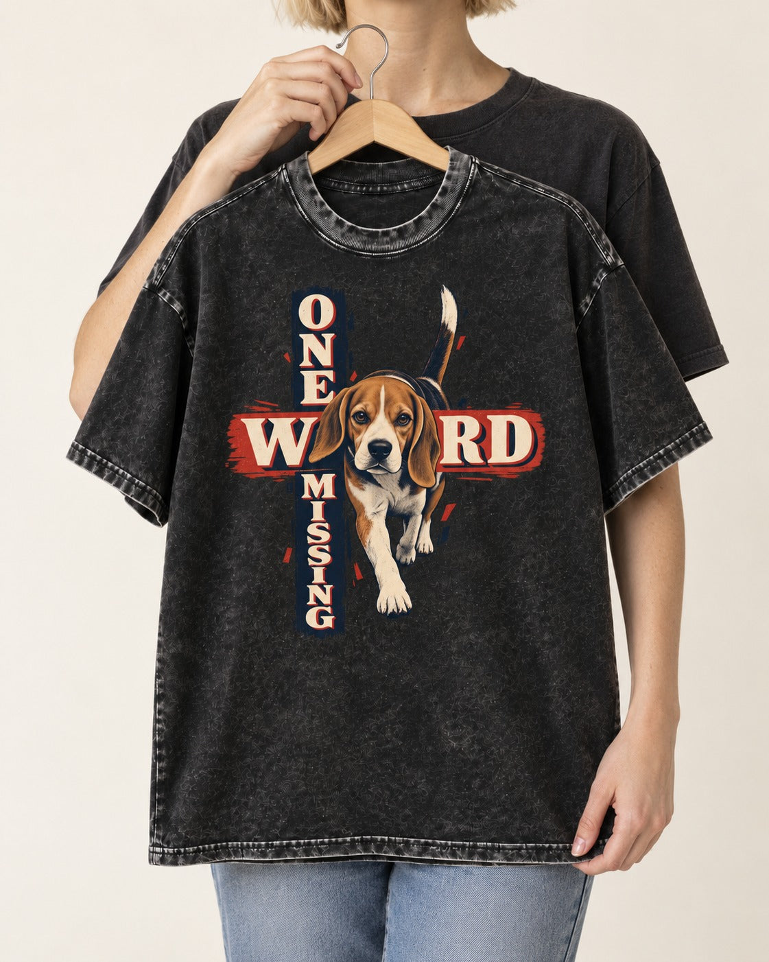 Beagle One Word Missing Washed Tee in Black, held up on a hanger