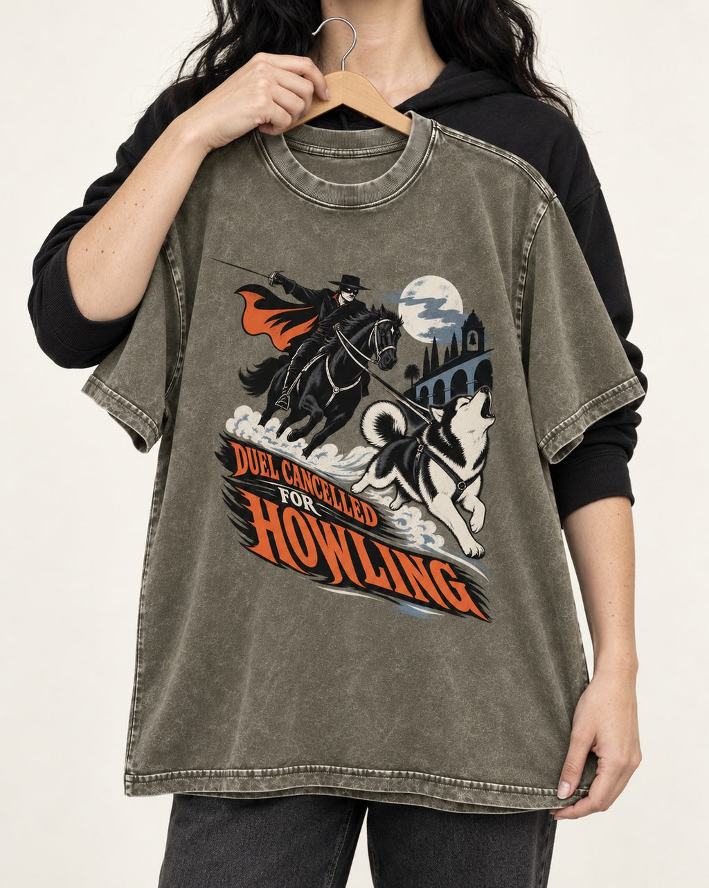 Husky Duel Cancelled for Howling Masked Rider Graphic Washed Tee in Army Green, held up on a hanger