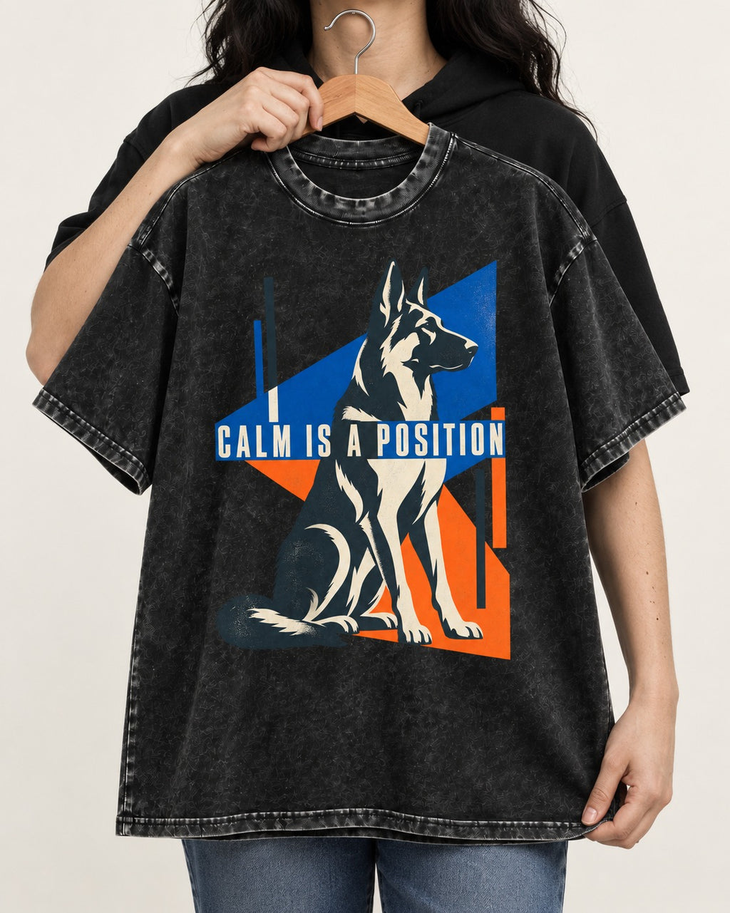 Calm Is A Position Geometric German Shepherd Dog Graphic Washed Tee in Black, held up on a hanger