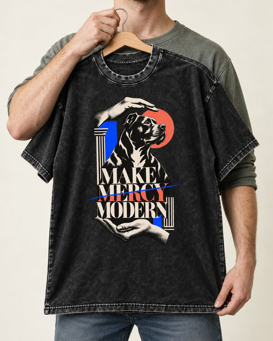 Pitbull Make Mercy Modern Protective Hands Graphic Washed Tee in Black, held up on a hanger