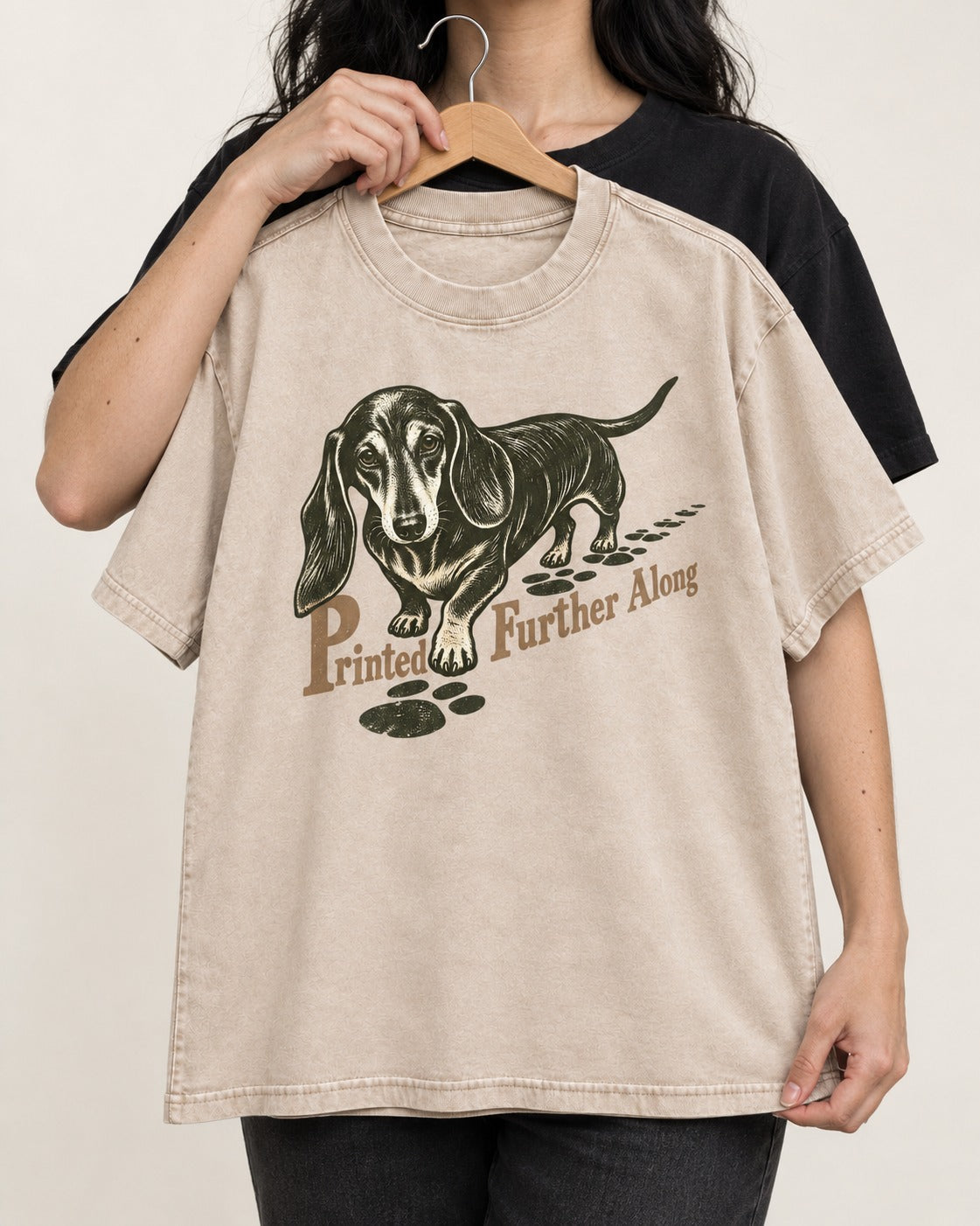 Dachshund Printed Further Along Footprint Graphic Washed Tee in Apricot, held up on a hanger