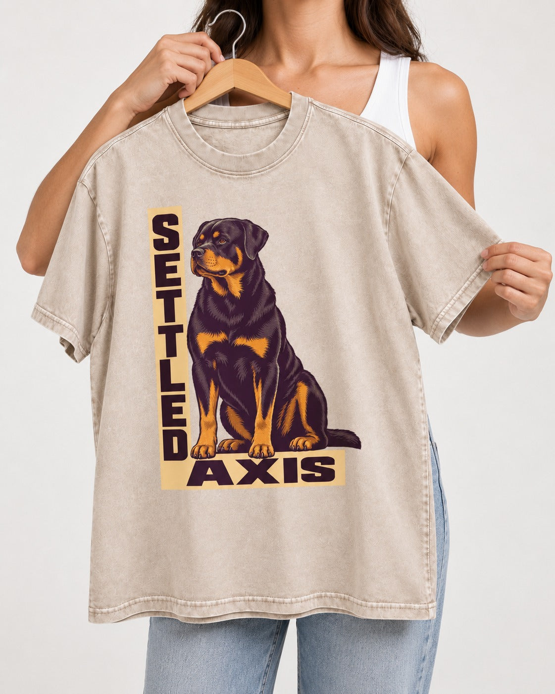 Settled Axis Rottweiler Washed Tee in Apricot, held up on a hanger