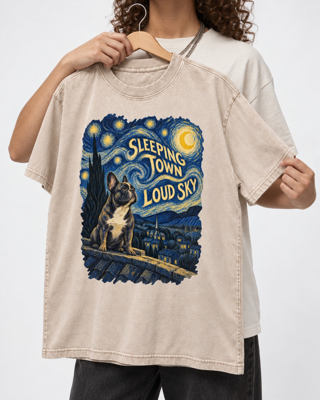 Frenchie Sleeping Town Loud Sky Rooftop Graphic Washed Tee in Apricot, held up on a hanger