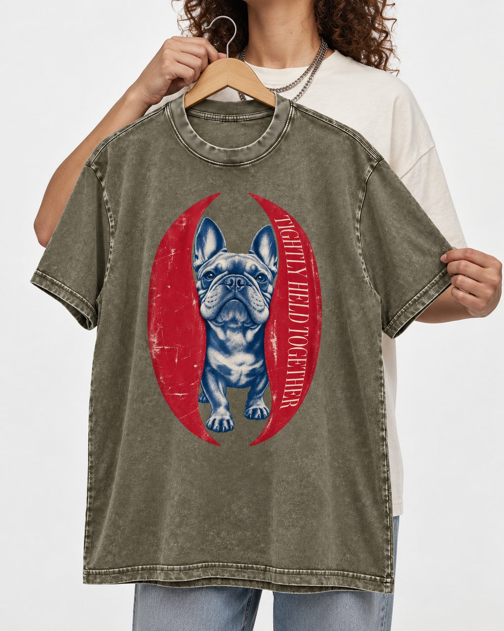 Frenchie Tightly Held Together Red Oval Graphic Washed Tee in Army Green, held up on a hanger