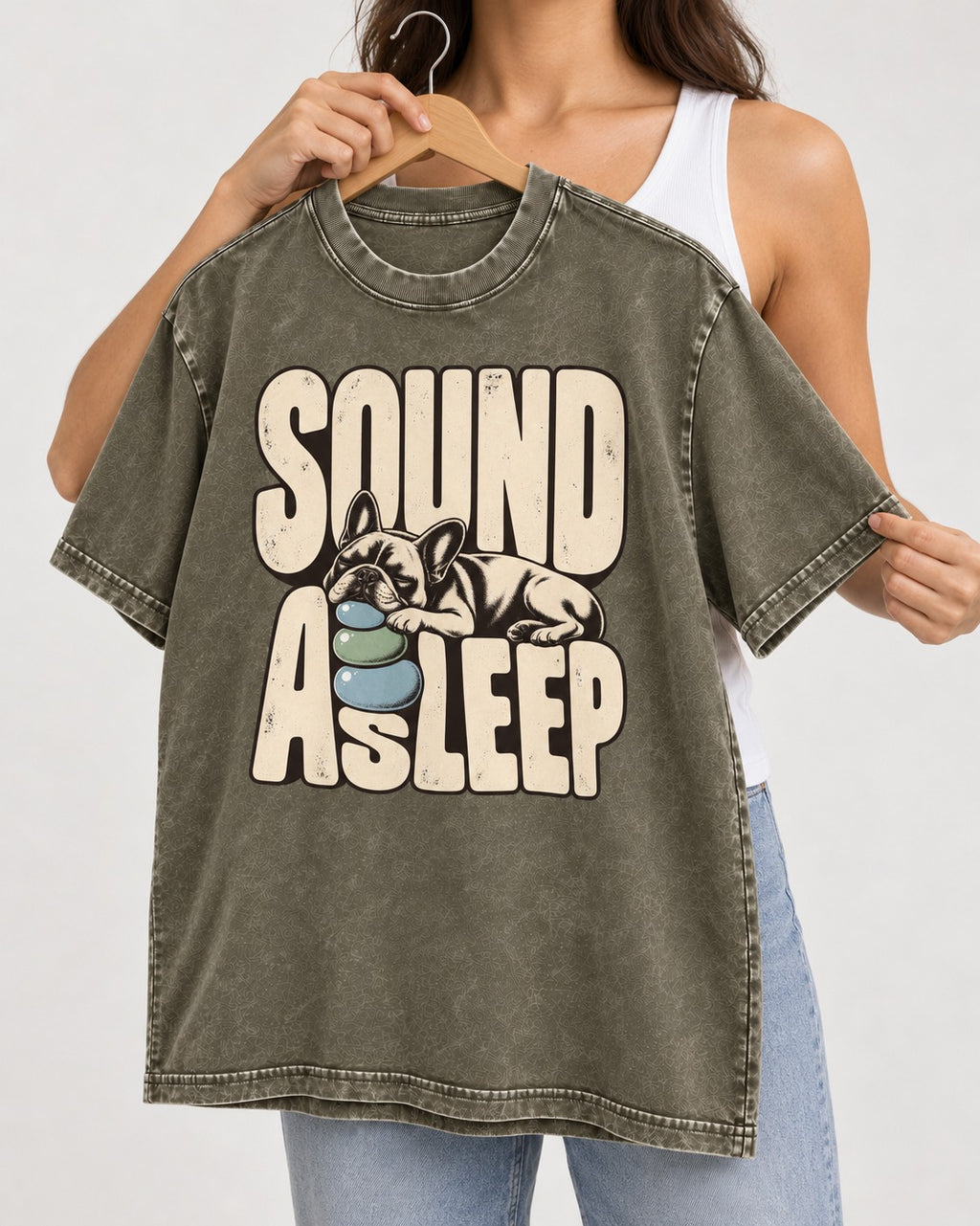 Frenchie Sound Asleep Stone Pillow Graphic Washed Tee in Army Green, held up on a hanger