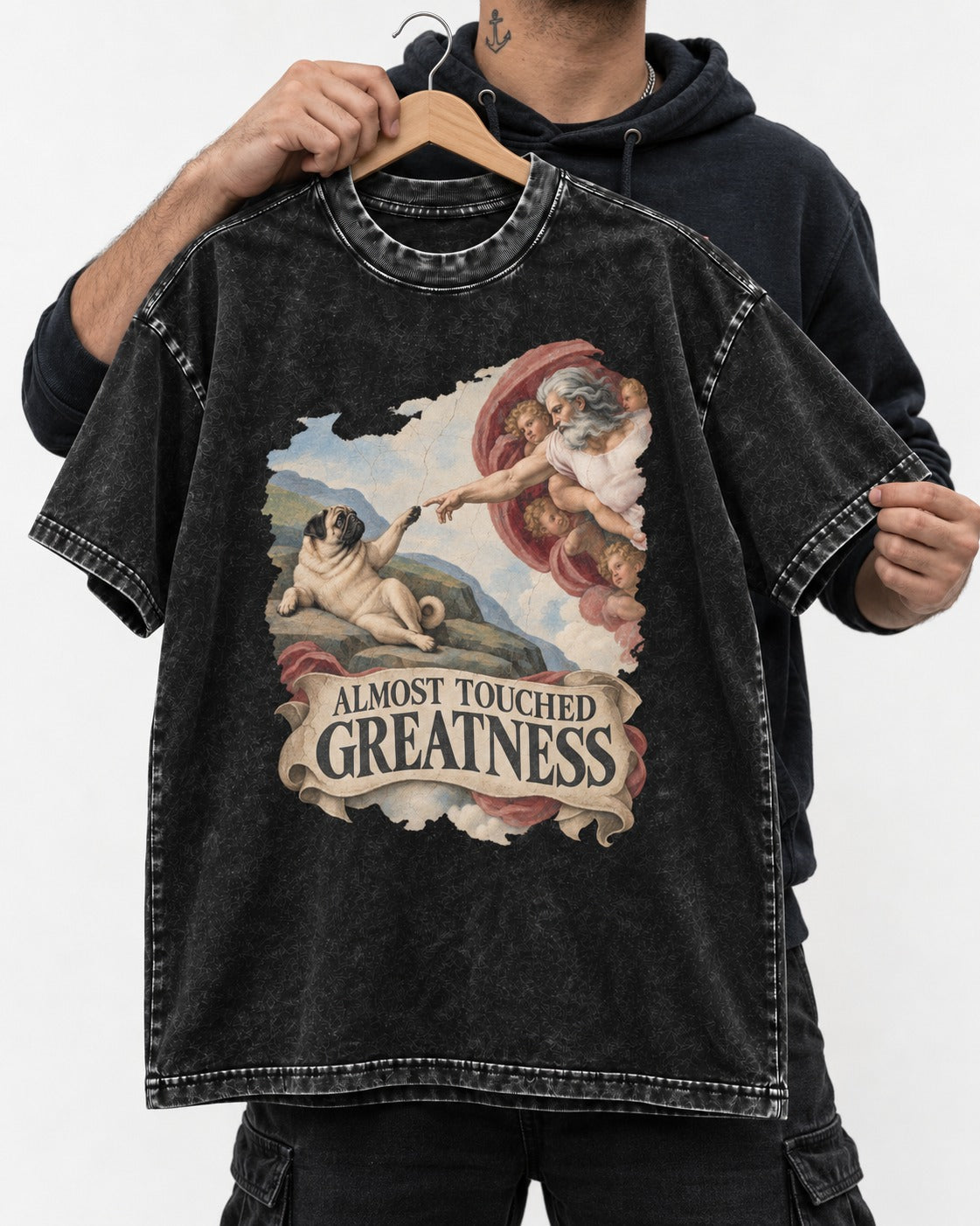 Pug Almost Touched Greatness Creation Parody Graphic Washed Tee in Black, held up on a hanger
