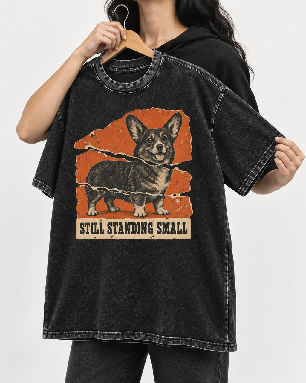 Corgi Still Standing Small Torn Poster Washed Tee in Black, held up on a hanger
