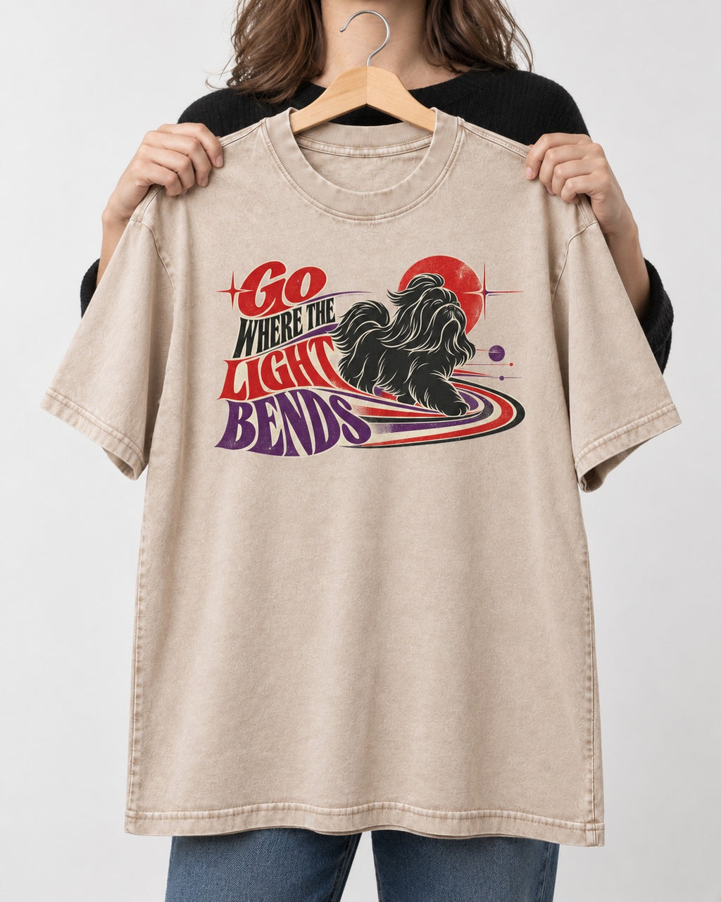 Shih Tzu Go Where the Light Bends Cosmic Orbit Graphic Washed Tee in Apricot, held up on a hanger