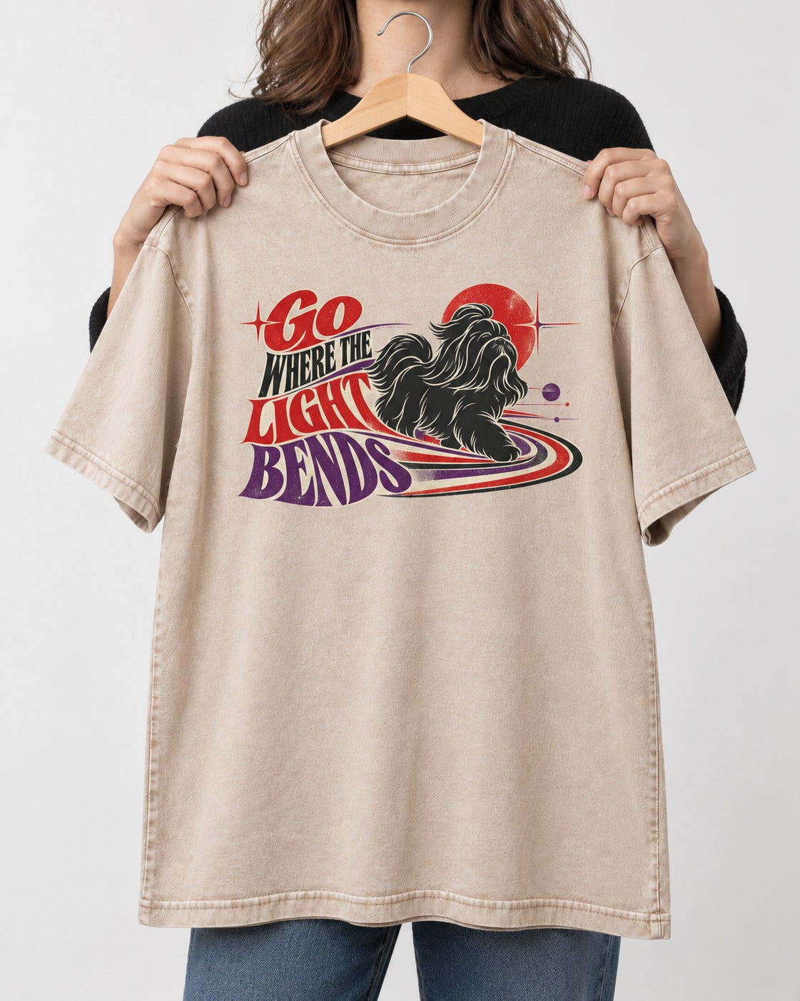 Shih Tzu Go Where the Light Bends Cosmic Orbit Graphic Washed Tee in Apricot, held up on a hanger