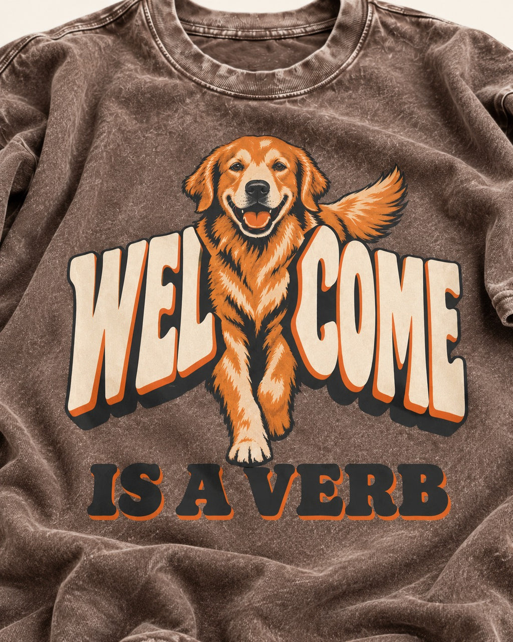 Golden Retriever Welcome Is a Verb Washed Tee in Coffee, close-up of the graphic
