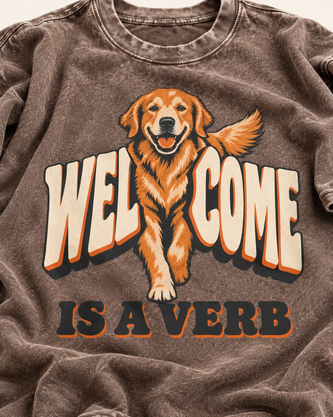 Golden Retriever Welcome Is a Verb Washed Tee in Coffee, close-up of the graphic