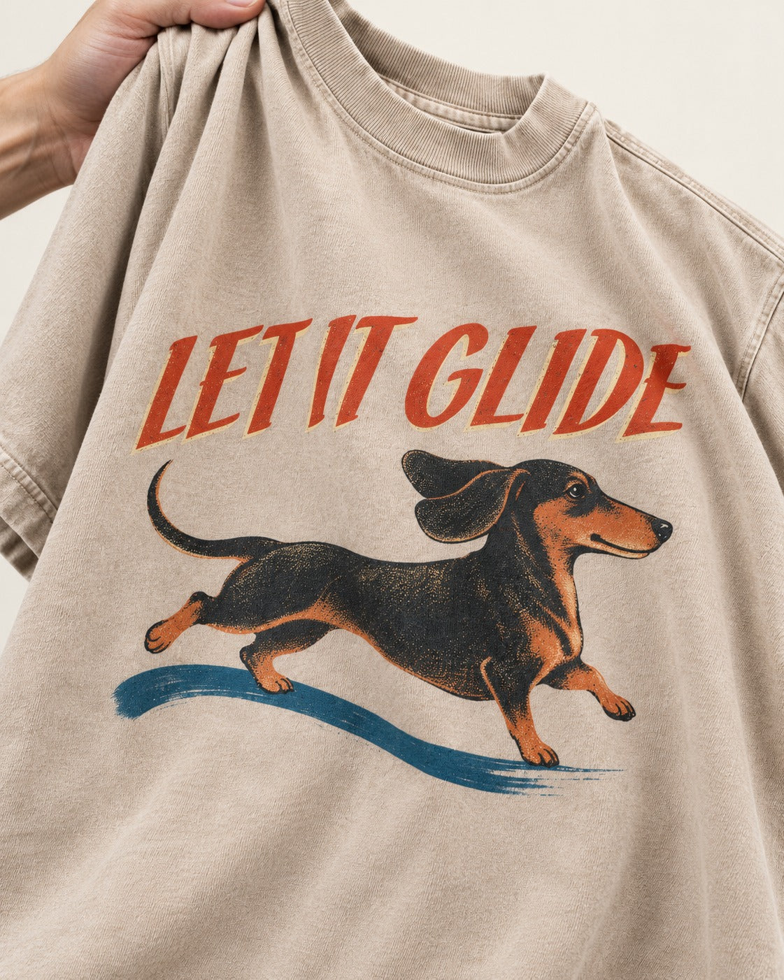 Let It Glide Dachshund Washed Tee in Apricot, close-up of the graphic