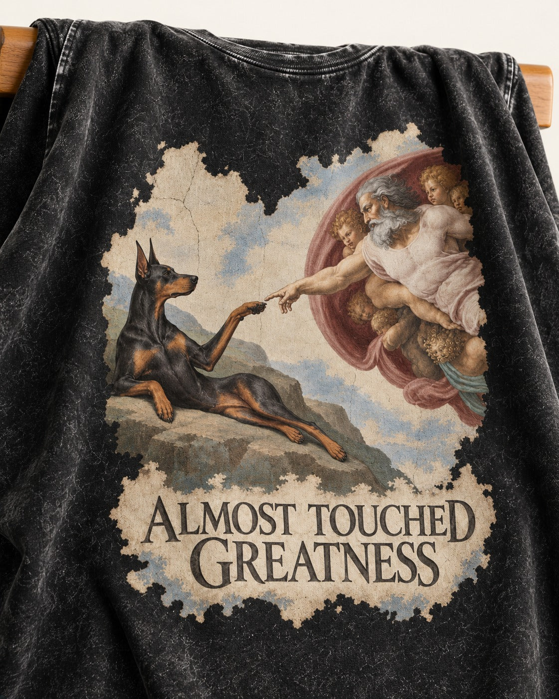 Doberman Almost Touched Greatness Creation Scene Graphic Washed Tee in Black, close-up of the graphic