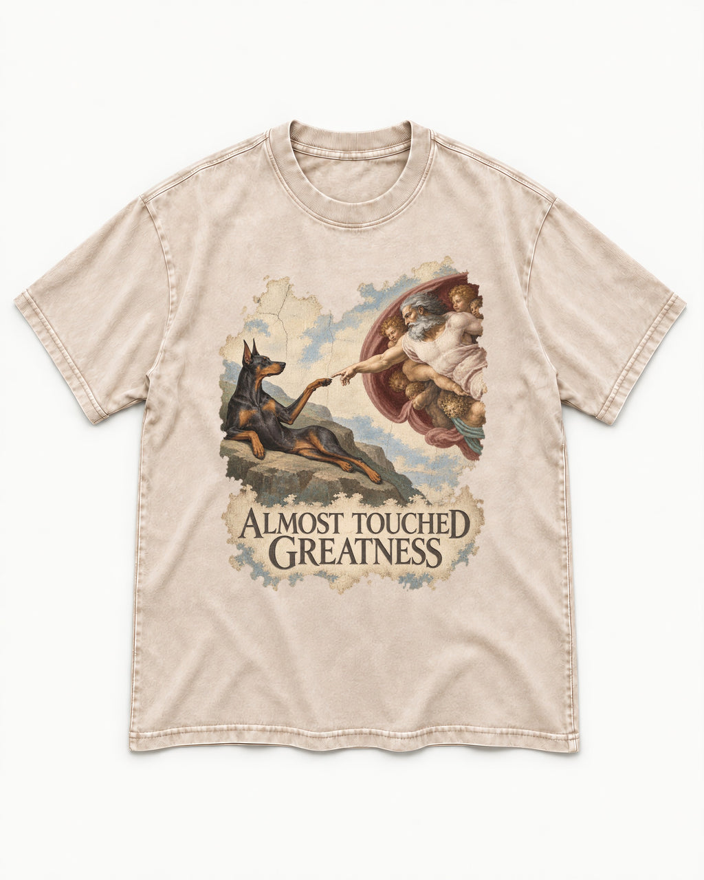 Doberman Almost Touched Greatness Creation Scene Graphic Washed Tee in Apricot, flat lay product photo